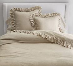 a bed with ruffles and pillows on it