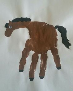 a brown horse made out of paper on a white sheet with black feet and tail