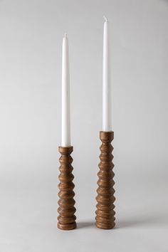 two white candles sitting next to each other