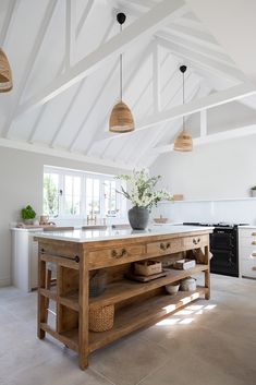 a large kitchen island in the middle of a room with white walls and ceilinging