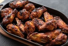 some chicken wings are cooking in a pan