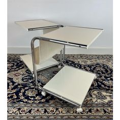 a chrome and glass side table on top of a rug