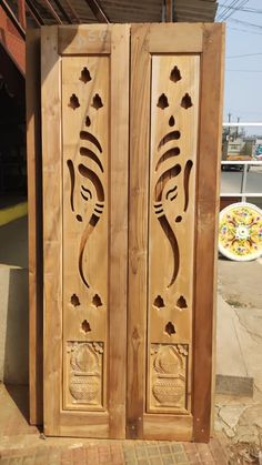 two wooden doors with carved designs on them