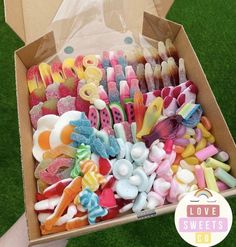 a box filled with lots of different colored toothbrushes on top of green grass