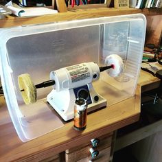 a machine that is sitting on top of a wooden table in front of a book shelf