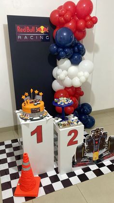 red bull racing themed birthday party with balloons and race cars on pedestals for the first place