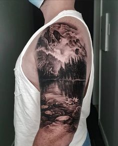 a man with a mountain scene tattoo on his arm