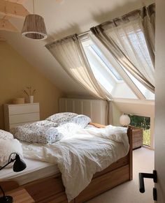 a bedroom with an unmade bed and two windows