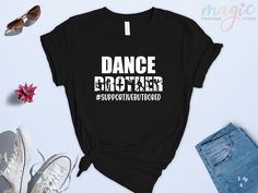 a black t - shirt with the words dance brother on it, surrounded by other items