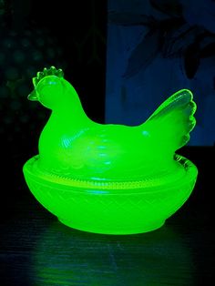 a neon green glass bowl with a chicken design on the front and sides, sitting on a table