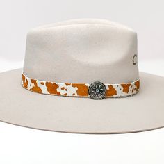 Cow Print Hat Band with Silver Tone Charm in Brown, and Ivory. Pictured on a white background with the band around a light tan/ brown hat. Cow Print Hat, Cowhide Print, Giddy Up Glamour, Hat Band, Cow Print, Sale Items, Cow, Silver Tone, Band