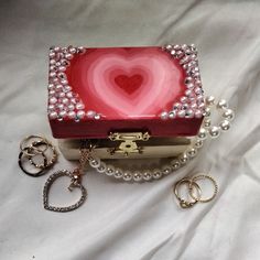 a heart shaped box with pearls around it