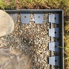 a metal box filled with lots of rocks and gravel next to a rock pile on the ground