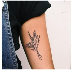 a person with a tattoo on their arm holding a flower in one hand and a plant in the other