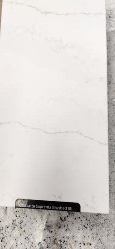 a white marble counter top sitting on top of a floor next to a black marker