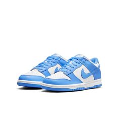 The Nike Dunk Low GS 'University Blue' is a sneaker that pays homage to its collegiate hardwood roots. This low-top shoe features a leather upper in a color-blocked design, with a crisp white base and pastel blue finish on the eyestay, Swoosh, and heel and forefoot overlays. Nike branding is featured on the tongue tag and heel tag, while the shoe sits on a durable rubber cupsole. The outsole provides performance-ready traction, making this sneaker perfect for big kids who want a stylish and functional sneaker. Nike Low Dunk, Unc University, Customized Shoes, Blue Jordans, Fresh Sneakers, Nike Models, Cute Nike Shoes, Cute Nikes, Sb Dunk