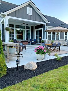 a patio with chairs and an umbrella in front of it