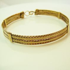 "A stylish and eye-catching bracelet, handcrafted with ten strands of 14kt gold filled wire in a classic wire-wrap style. Six strands of twist wire, two on each side and two in the middle, spaced with four strands of plain square wire, two on each side of the middle. Dress it up or down--it's definitely a wear-with everything accessory! And stackable with so many of my other bracelet styles. There's nothing like an armful of affordable gorgeousness! The built-in hook and eye-type clasp is easy t Handmade Yellow Gold Bangle Chain Bracelet, Handmade Yellow Gold Bangle Bracelet, Handmade Adjustable Gold Bracelet, Adjustable Unique Bangle Chain Bracelet, Handmade Double Band Bracelet As Gift, Unique Adjustable Chain Bangle Bracelet, Handmade Adjustable Yellow Gold Bracelet, Unique Adjustable Bangle Chain Bracelet, Elegant Handmade Double Band Jewelry