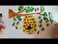 someone is drawing a beehive with honeycombs on the tree branch and green leaves