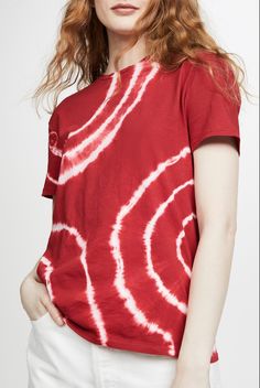 a woman wearing a red shirt with white swirls on it