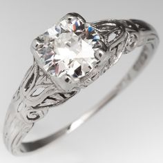 an antique style diamond ring with filigrees on the band and center stone