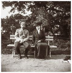 an old black and white photo of two people sitting on a bench