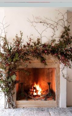 the fireplace is decorated with branches and flowers