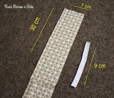 the measuring tape is next to an untied tie on the floor with measurements