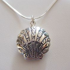 Locket Details: This shell locket is made of genuine 925 Sterling Silver Stamped 925 Holds two photos Includes 18" 925 Sterling Silver snake chain with spring ring clasp Measurements: 25mm x 22mm x 8mm (1" x 7/8" x 5/16") Arrives in a gift box Shipping Details: All orders are shipped within 1 business day (excluding US Holidays) All orders are shipped from Texas, USA International Buyers: Please see Shipping & Payments tab regarding Customs Fees Return Details: Risk-Free 30-Day Return Policy Customer Service: 9am to 4pm CST Monday-Friday (excluding US Holidays) Please message us with any questions! Elegant Silver Necklace For Beach, Silver Engraved Necklace For Beach, Silver Shell Jewelry With Lobster Clasp, Silver Shell-shaped Jewelry With Lobster Clasp, Necklaces Wire, Seashell Locket, Silver Earrings Outfit, Shell Locket, Look 80s