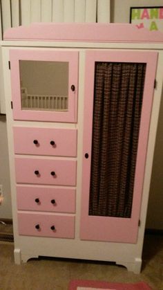 a white and pink dresser with drawers on top of it's sides in a room