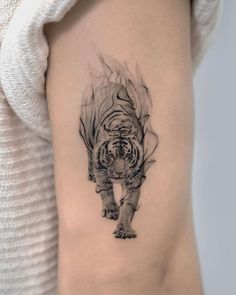 a woman's thigh with a black and white tattoo of a tiger on it