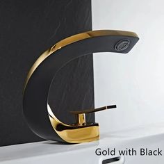 a black and gold bathroom faucet sitting on top of a white counter