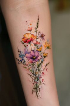 a colorful flower tattoo on the left arm and leg, with watercolor flowers all over it