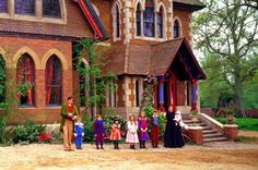 a group of children standing in front of a house