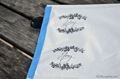 two napkins with monogrammed designs on them sitting on a wooden table top