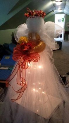 an angel made out of tulle with lights on it's head and wings