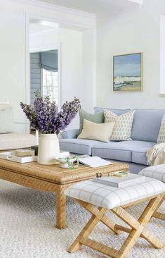 a living room with blue couches and white chairs in front of a coffee table