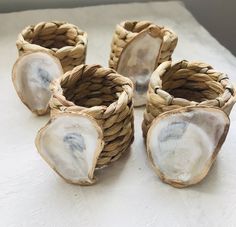 four pieces of wicker sitting on top of a white cloth covered table next to each other