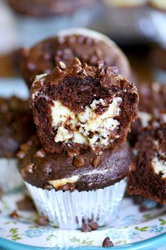 chocolate cupcakes with white frosting and chopped nuts on a blue and white plate