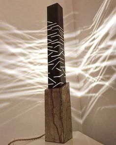 a sculpture made out of wood and wire on top of a white surface with light streaming through it