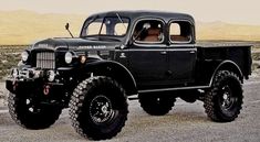 an old black truck is parked in the desert