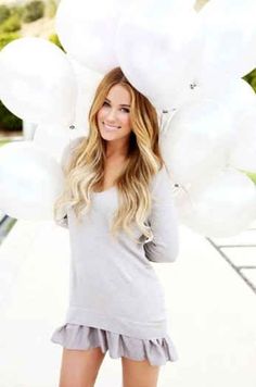 a woman is posing with balloons on her head