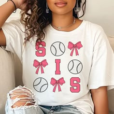 a woman sitting on a couch wearing a t - shirt with baseballs and bows