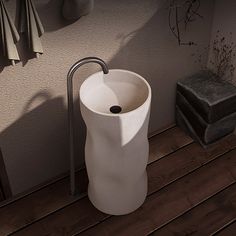 a white sink sitting on top of a wooden floor next to a wall mounted faucet