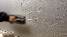 a man painting a wall with white paint