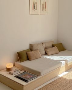 a bed sitting on top of a wooden platform next to a wall with pictures above it