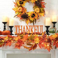 a decorated mantle with candles and fall leaves