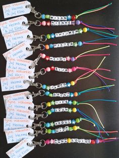 several name tags are attached to lanyards with colorful beads and charms on them