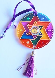 a colorful ornament hanging from a purple ribbon