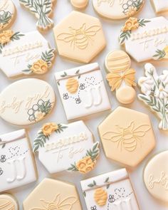 decorated cookies are arranged in rows on a white surface with flowers and honeycombs